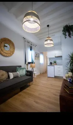 a living room with a couch and two lights at Pitusa Home in Cádiz
