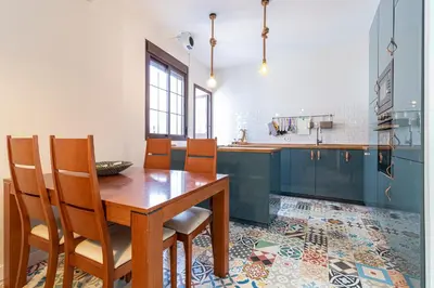 a kitchen with a wooden table and chairs at Allo Apartments Remedios Centro 2 Habitaciones in Jerez de la Frontera