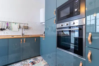 a kitchen with blue cabinets and a microwave at Allo Apartments Remedios Centro 2 Habitaciones in Jerez de la Frontera