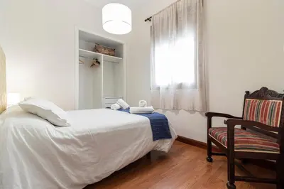 a bedroom with a bed and a chair and a window at Allo Apartments Remedios Centro 2 Habitaciones in Jerez de la Frontera