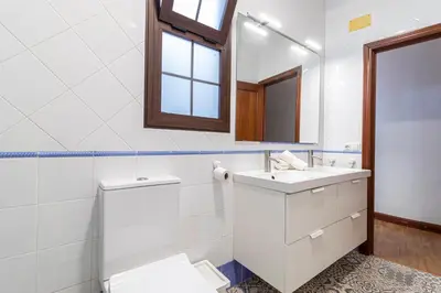 a white bathroom with a sink and a mirror at Allo Apartments Remedios Centro 2 Habitaciones in Jerez de la Frontera
