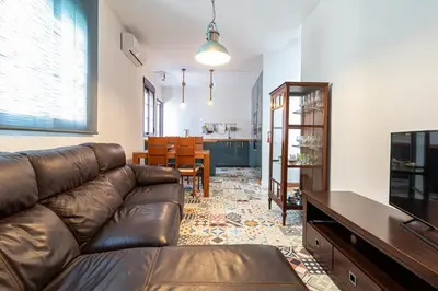 a living room with a leather couch and a dining room at Allo Apartments Remedios Centro 2 Habitaciones in Jerez de la Frontera