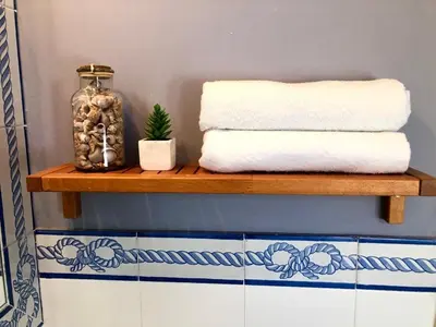 a shelf with towels and a glass jar on it at GATU PREMIUM Atico Sotavento playa, parking, terraza, piscinas, wifi y aire acc , 
