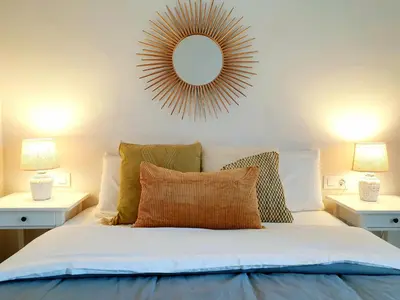 a bedroom with a bed with a mirror on the wall at Sherryflat C/ Arcos in Jerez de la Frontera