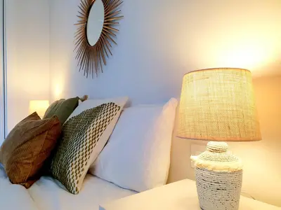 a bedroom with a bed with pillows and a lamp at Sherryflat C/ Arcos in Jerez de la Frontera