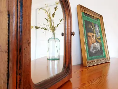 a vase on a table with a painting and a mirror at Sherryflat C/ Arcos in Jerez de la Frontera