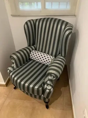 a black and white striped chair with a pillow at Palma 2 sueños in Jerez de la Frontera