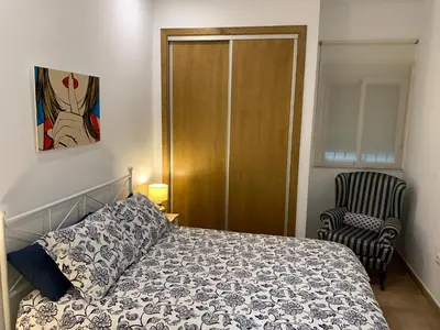 a bedroom with a bed and a chair at Palma 2 sueños in Jerez de la Frontera