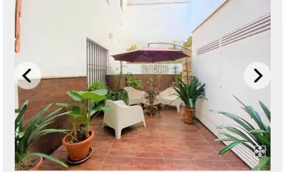 a patio with an umbrella and chairs and plants at Palma 2 sueños in Jerez de la Frontera