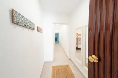 a hallway with a wooden door and a rug at Apartamento Centro Calle Plata in Sanlúcar de Barrameda