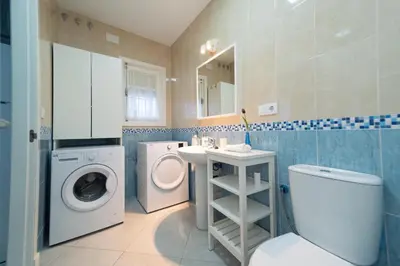 a bathroom with a washing machine and a washer and dryer at Apartamento Centro Calle Plata in Sanlúcar de Barrameda