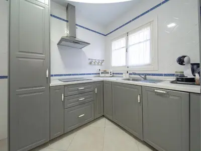 a kitchen with gray cabinets and a sink and a window at Apartamento Centro Calle Plata in Sanlúcar de Barrameda