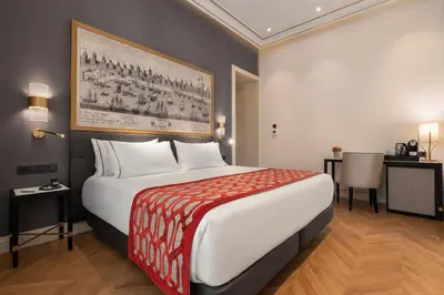a hotel room with a large bed and a table at Áurea Casa Palacio Sagasta by Eurostars Hotel Company in Cádiz