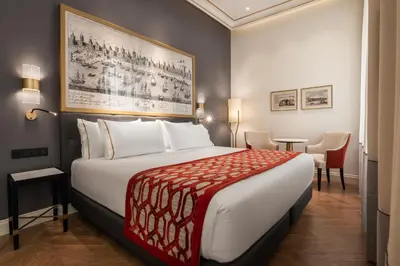 a hotel room with a large bed and a table at Áurea Casa Palacio Sagasta by Eurostars Hotel Company in Cádiz
