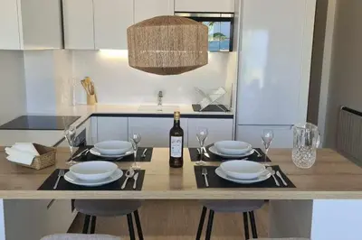 a kitchen with a table with plates and a bottle of wine at Boutelou playa con vistas al mar in Sanlúcar de Barrameda