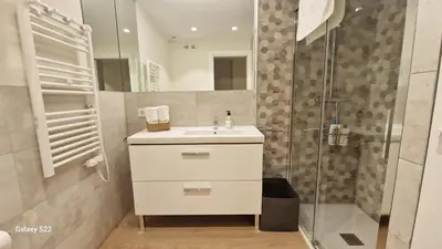 a white bathroom with a sink and a shower at Boutelou playa con vistas al mar in Sanlúcar de Barrameda