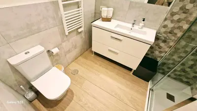 a bathroom with a white toilet and a sink at Boutelou playa con vistas al mar in Sanlúcar de Barrameda