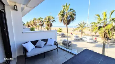 a balcony with a couch and a view of the beach at Boutelou playa con vistas al mar in Sanlúcar de Barrameda