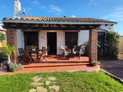 a patio with a table and chairs under a pergola at Casa Juanse in Conil de la Frontera