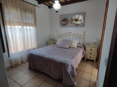 a bedroom with a bed and a large window at Casa Juanse in Conil de la Frontera