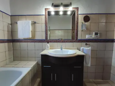 a bathroom with a sink and a mirror and a tub at Casa Juanse in Conil de la Frontera