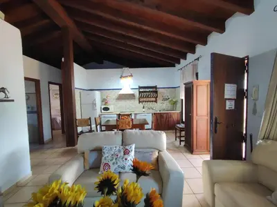a living room with a couch and a kitchen at Casa Juanse in Conil de la Frontera