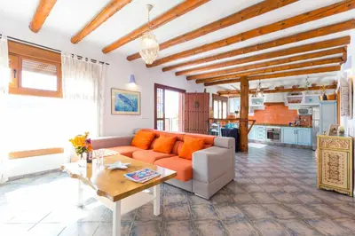 a living room with an orange couch and a table at La Ballena Azul CONIL in Cádiz