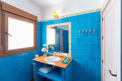 a blue bathroom with a sink and a mirror at La Ballena Azul CONIL in Cádiz