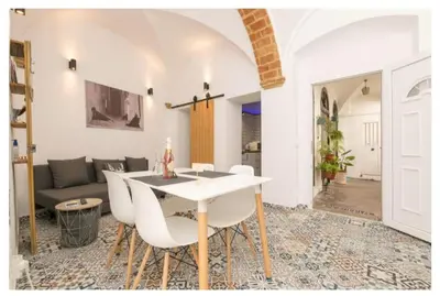 a living room with a white table and white chairs at Casa Cuna in Arcos de la Frontera