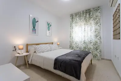 a bedroom with a bed and a large window at Cielos 57 in El Puerto de Santa María