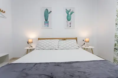 a bedroom with a white bed with two tables at Cielos 57 in El Puerto de Santa María