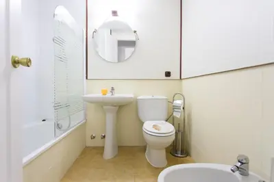 a bathroom with a toilet and a sink and a mirror at Cielos 57 in El Puerto de Santa María