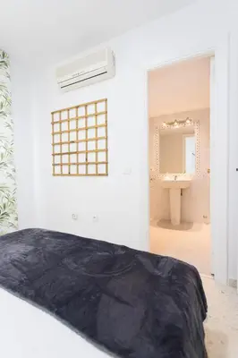 a bedroom with a bed and a bathroom with a sink at Cielos 57 in El Puerto de Santa María