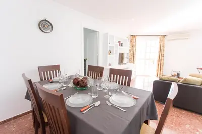 a dining room with a table with plates and glasses at Cielos 57 in El Puerto de Santa María