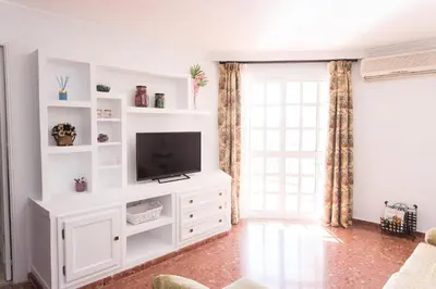 a living room with a television on a white entertainment center at Cielos 57 in El Puerto de Santa María
