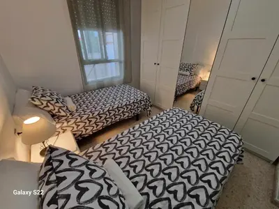 a small room with two beds and a couch at Guadalquivir amplio y céntrico in Sanlúcar de Barrameda