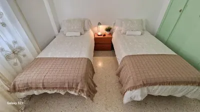 two beds sitting next to each other in a bedroom at Guadalquivir amplio y céntrico in Sanlúcar de Barrameda