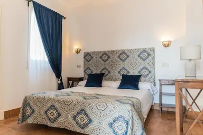 a bedroom with a large bed with blue pillows at La Gitanilla Alojamiento & Encanto Jerez in Jerez de la Frontera