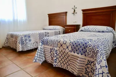 two beds in a room with blue and white blankets at Fuente del Gallo Nomada in Conil de la Frontera