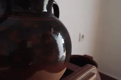 a black vase sitting on top of a table at Fuente del Gallo Nomada in Conil de la Frontera
