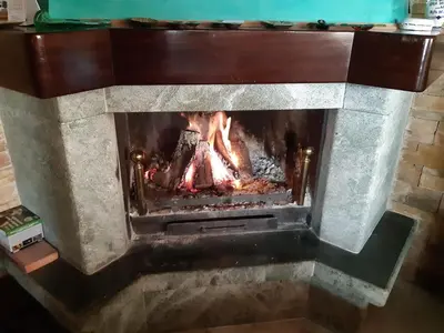 a stone fireplace with a fire in it at Casa Grande Zona Norte in Jerez de la Frontera