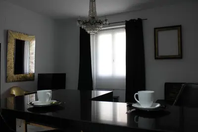 a dining room with a black table and a chandelier at Luxury apartament in Cádiz