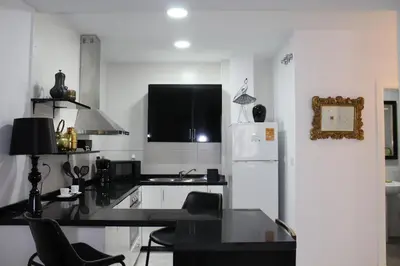 a kitchen with a black counter top and a refrigerator at Luxury apartament in Cádiz