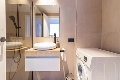 a bathroom with a washing machine and a mirror at Allo Apartments Francos II Parking Centro 2 Habitaciones in Jerez de la Frontera