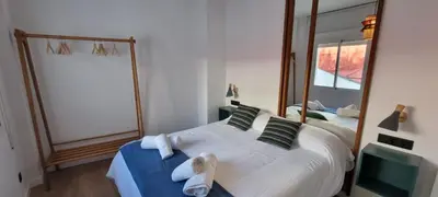 a bedroom with a large bed and a mirror at Allo Apartments Francos II Parking Centro 2 Habitaciones in Jerez de la Frontera