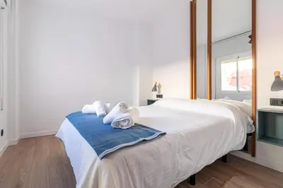 a bedroom with a large white bed with towels on it at Allo Apartments Francos II Parking Centro 2 Habitaciones in Jerez de la Frontera