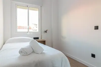 a white bedroom with a bed with towels on it at Allo Apartments Francos II Parking Centro 2 Habitaciones in Jerez de la Frontera
