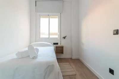 a white bedroom with a bed and a window at Allo Apartments Francos II Parking Centro 2 Habitaciones in Jerez de la Frontera