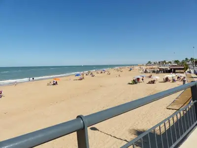 a group of people on a beach with the ocean at Apartamento en la playa cruz del mar chipiona in Chipiona
