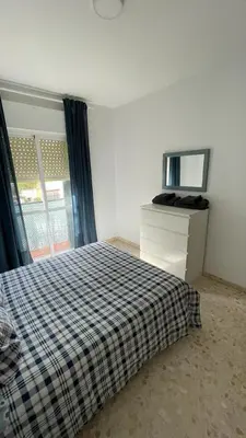 a bedroom with a bed and a dresser and a mirror at Apartamento en la playa cruz del mar chipiona in Chipiona